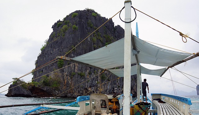El Nido, Παλάουαν: Άνθρωποι, περιηγήσεις στα νησιά και νυχτερινή ζωή 1 Σκάφος μπροστά από ασβεστολιθικό νησί στο El Nido του Παλάουαν
